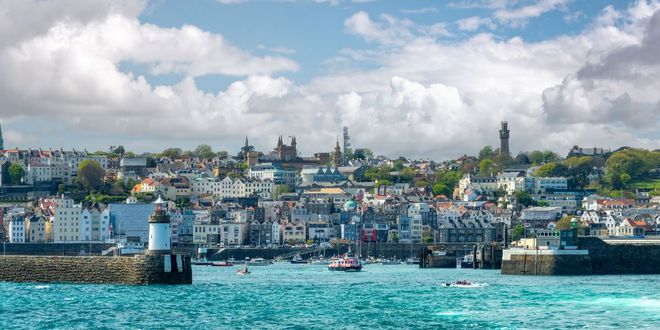 The harbor, the lighthouse and the town of St Peter Port in Guernsey