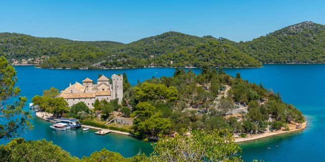 A stone monastery on a small lush island in the middle of a saltwater lake in Mljet, Croatia