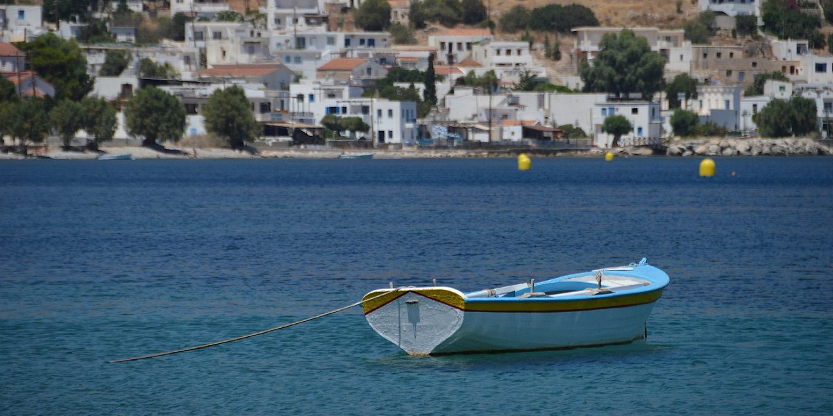 γαλάζια και άσπρη βάρκα, μπλε θάλασσα στη Χάλκη, άσπρα σπίτια