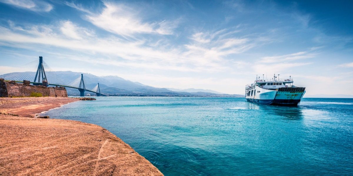 Ferry boat outside of Patras, Peloponnese and view of the Rio-Antirio bridge, blue sea, clouds