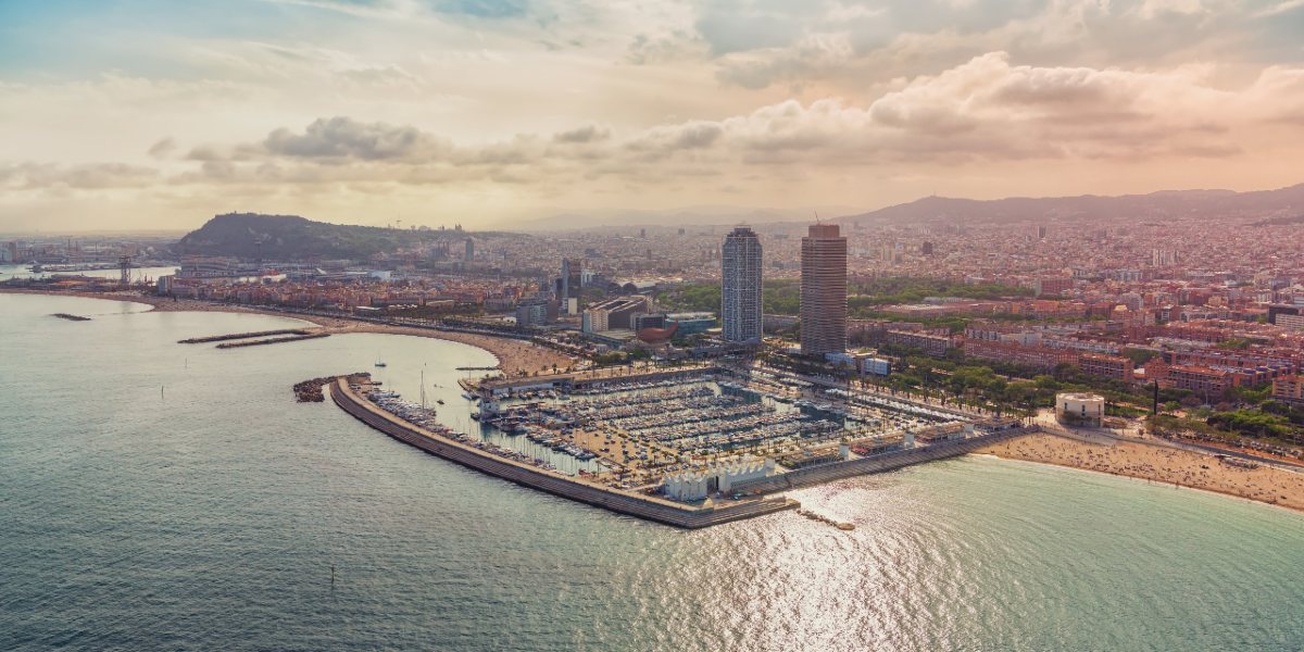 Vista de la ciudad y el puerto de Barcelona, arquitectura, colores del atardecer, rutas de ferry.