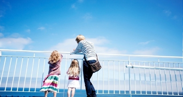 Family gazing at the Balearic Sea from the ferry deck