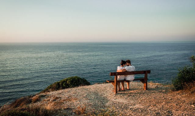 Ein Urlaubspärchen genießt den romantischen Ausblick von den Kykladen aus