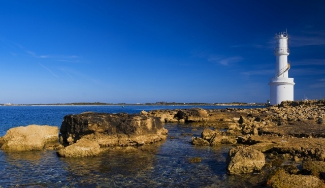 La costa rocciosa e il faro bianco di La Savina a Formentera