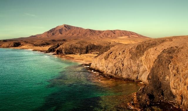 Yellow mountains and crystalline waters at Papagayo Beach in Lanzarote