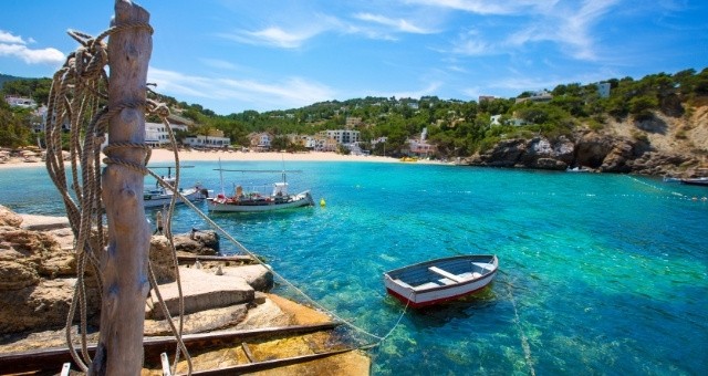 Piccole imbarcazioni nella spiaggia di Cala Vadella a Ibiza, Isole Baleari, Spagna