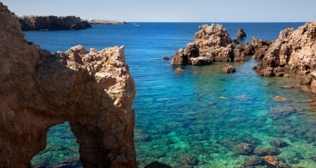 Rocky beach with crystal-clear waters in Menorca, Spain