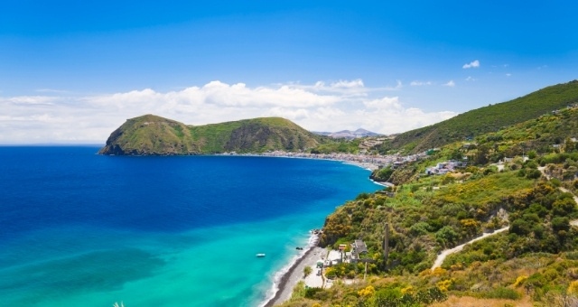 Colline verdi che circondano una spiaggia sull'isola di Lipari, Isole Eolie