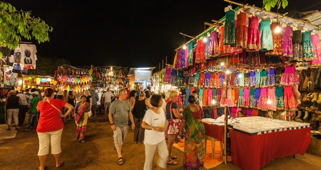 Mercado callejero por la noche y gente paseando