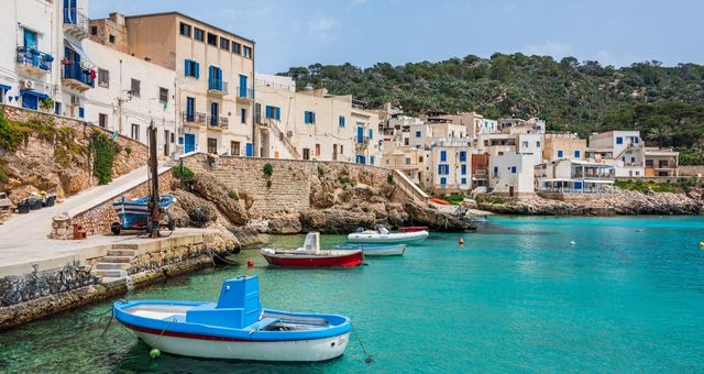 Fishing boats and turquoise waters in the port of Levanzo, Italy