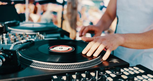 DJ’s hands on a console at a beach party in Sardinia, Italy