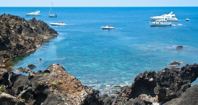 Boats at a cove with turquoise waters in Ustica, Italy