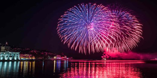 Serata di fuochi d’artificio in un porto d’Italia
