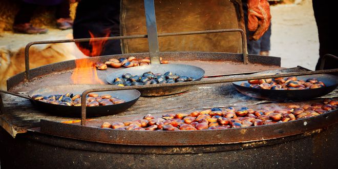 Castagne arrostite sul fuoco in antiche padelle di rame in Italia