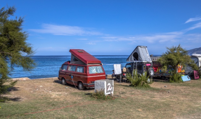 Wohnmobile direkt am Ufer auf einem Campingplatz auf Korsika 