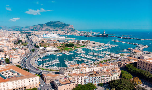 Aerial view of Palermo in Sicily, Italy, showing the harbor filled with boats and Mount Pellegrino in the background