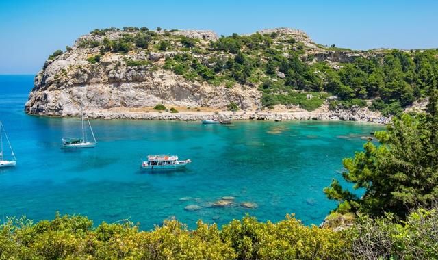 Le acque turchesi e la fitta vegetazione di una caletta a Rodi in Grecia