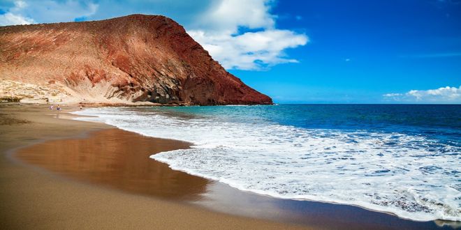 Плаж със златист пясък и планина на заден план в южната част на Тенерифе