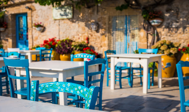 Bunte Tische und Stühle in einer traditionellen Trattoria in Sizilien, Italien