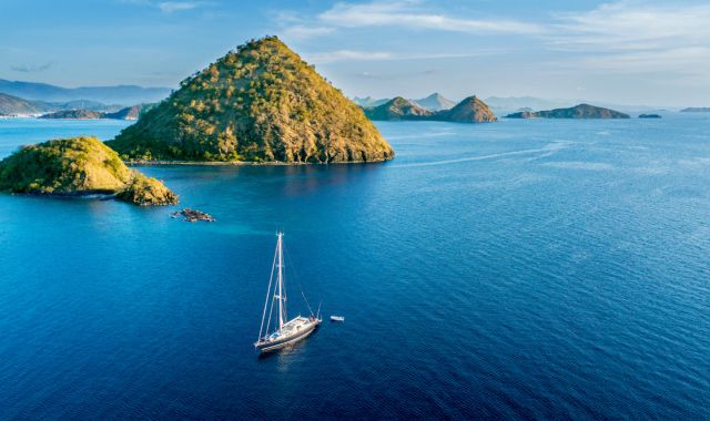 Aerial view of sailboat with island under blue sky in Labuan Bajo near Bali Island, Indonesia