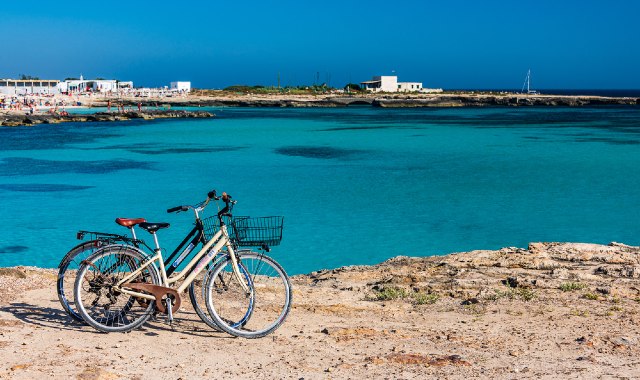 Biciclette parcheggiate vicino alle acque turchesi di Lido Burrone, a Favignana, nelle Isole Egadi, Sicilia