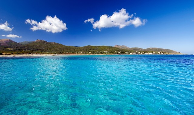 La spiaggia di Barcaggio si intravede in lontananza, vista dal mare turchese 