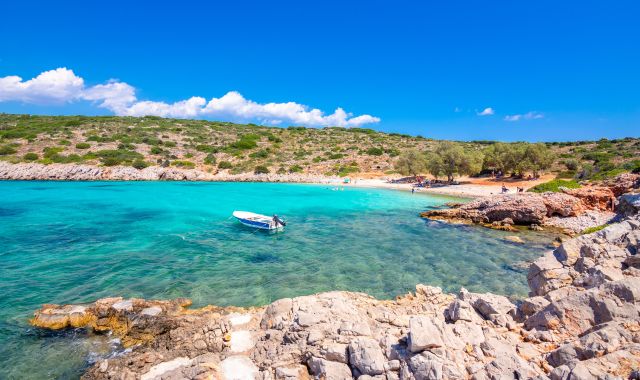 View of Agia Dinami beach, with boat and beachgoers, Chios, Greece