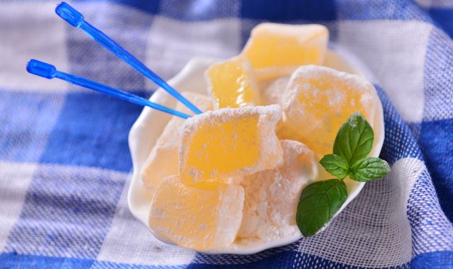 Bowl with loukoumia sweets dusted with sugar on table