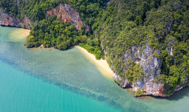 Bird's-eye view of towering cliffs with small beaches below them near Ao Nam Mao in Thailand