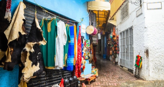 Narrow alley in Tangier’s old Medina with shops, signs and traditional Moroccan architecture