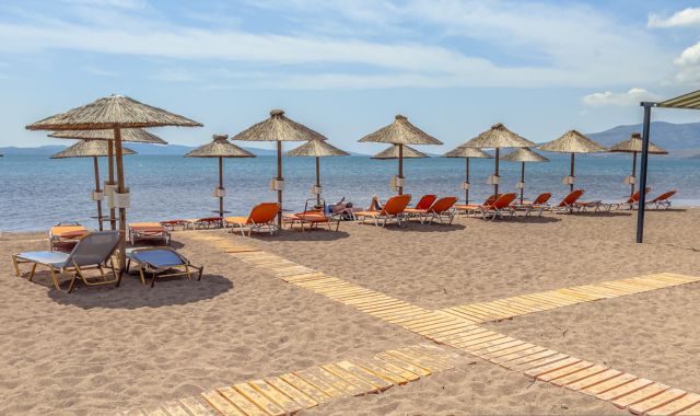 View of parasols and sun loungers on beach, Lesbos, Greece