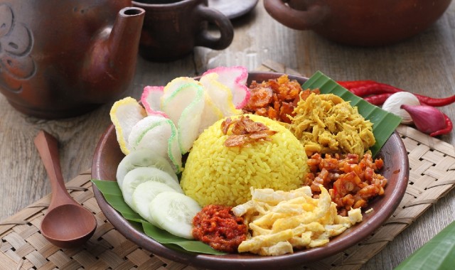 Nasi kuning, an Indonesian traditional dish consisting of rice, meat, and vegetables, served on a restaurant table