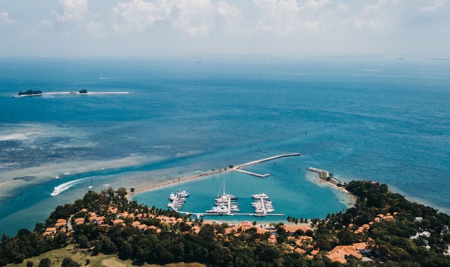  Aerial view of a harbor in Nongsa, Batam, Indonesia, with boats moored in the blue sea