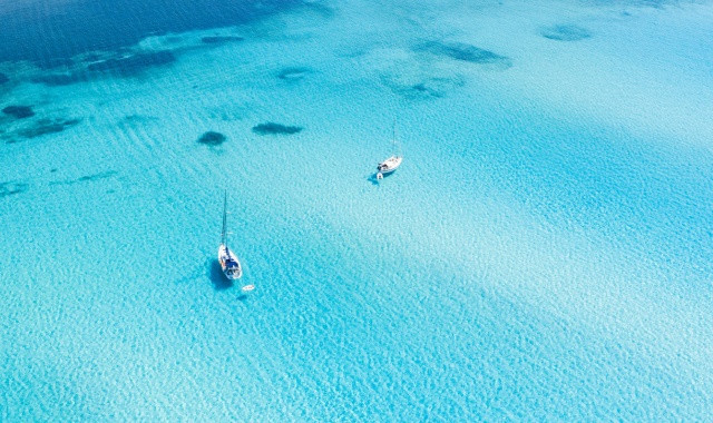 Das türkisfarbene Meer bei La Pelosa von oben mit 2 Segelbooten
