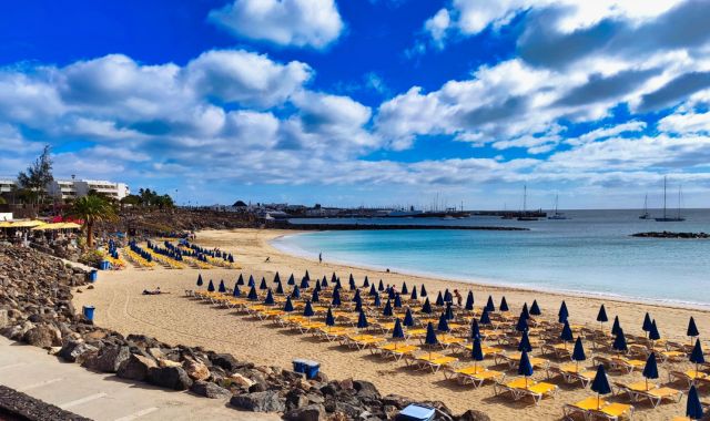 File di lettini e ombrelloni sulla spiaggia di Playa Blanca a Lanzarote