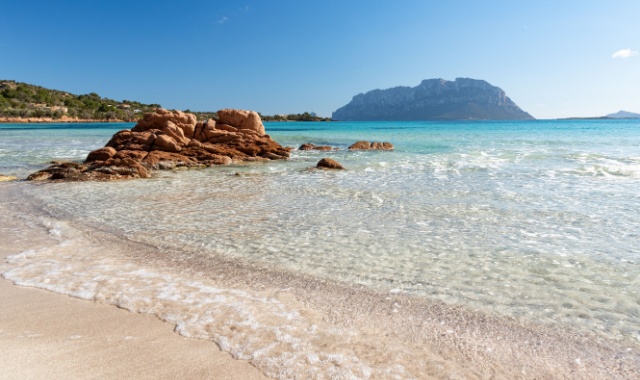 Rote Felsen im seichten Wasser des Trandes Porto Istana bei Olbia