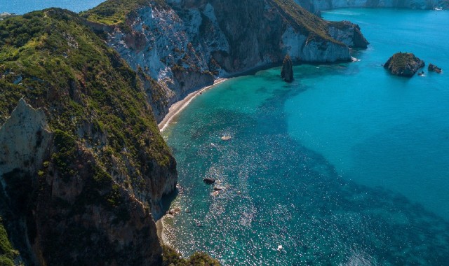 Il mare cristallino della spiaggia di Frontone, con alle spalle delle scogliere alte di tufo bianco