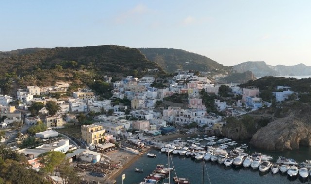 Casette bianche e colorate nel borgo di Santa Maria a Ponza, di fronte a un piccolo porticciolo