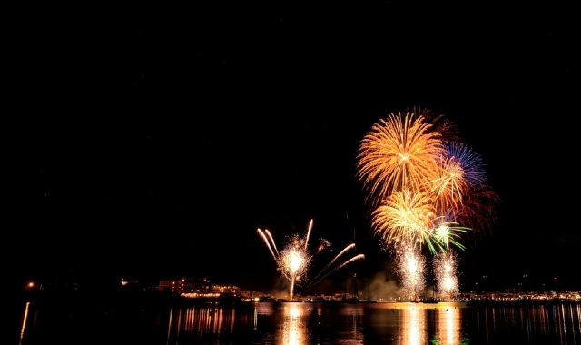 Fuochi d'artificio che illuminano il cielo notturno di Golfo Aranci in riva al mare.