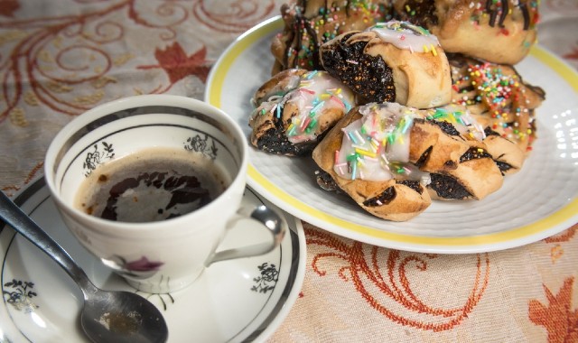 Dolcetti natalizi tipici di Trapani a base di fichi secchi, chiamati Cosi di Ficu, su un tavolo con un caffè