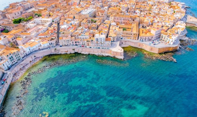 Vista aerea dell'isola di Ortigia a Siracusa, con il mare che luccica sotto il sole