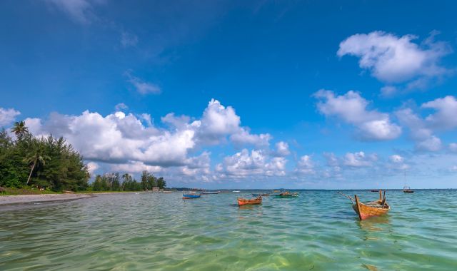 View of boats and beach with tropical trees in Batam, Indonesia