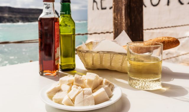 View of goats cheese, oil and bread on plate by the sea