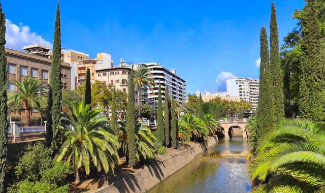 Il quartiere di Santa Catalina a Palma di Maiorca, con un ponte che attraversa un fiume e alberi che emergono tra gli edifici