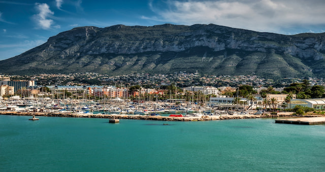 A harbor filled with moored luxury yachts and sailboats in Dénia, Spain 