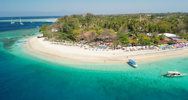 White sand beach with traditional outrigger boats and turquoise waters at Gili Air, Indonesia