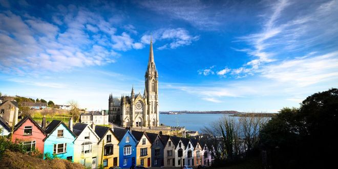 View of Saint Colmans Cathedral and colourful houses in Cobn near Cork, Republic of Ireland