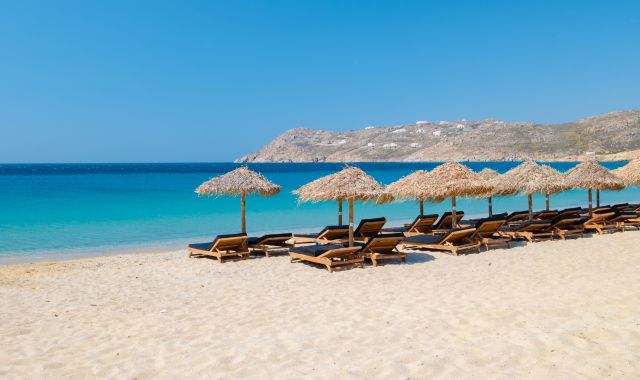 View of sunloungers and umbrellas on Elia beach, Mykonos, Cyclades, Greece