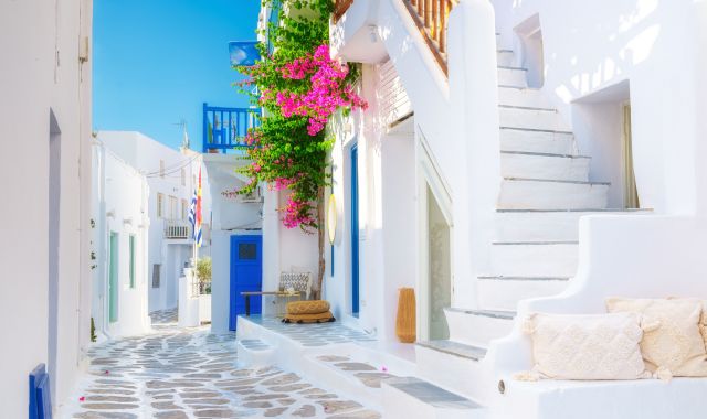 Alley with whitewashed houses and bougainvilleas in Mykonos, Cyclades, Greece