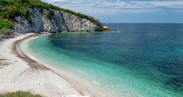 White shingle shore and clear sea at Capo Bianco Beach in Elba, Italy